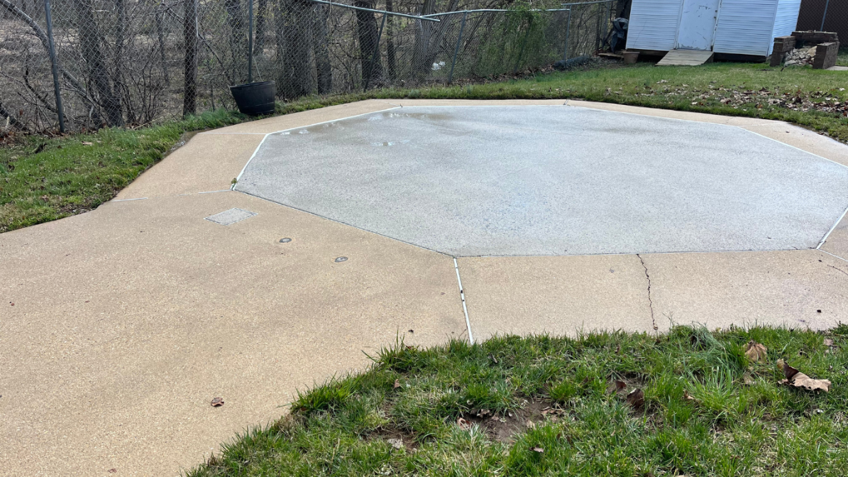 Light-colored etched halo around an oil stain on concrete caused by high-pressure washing