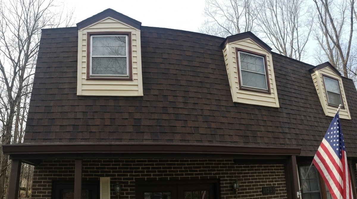 Mid-century ranch house in Newington Connecticut with a long roofline and mature trees.